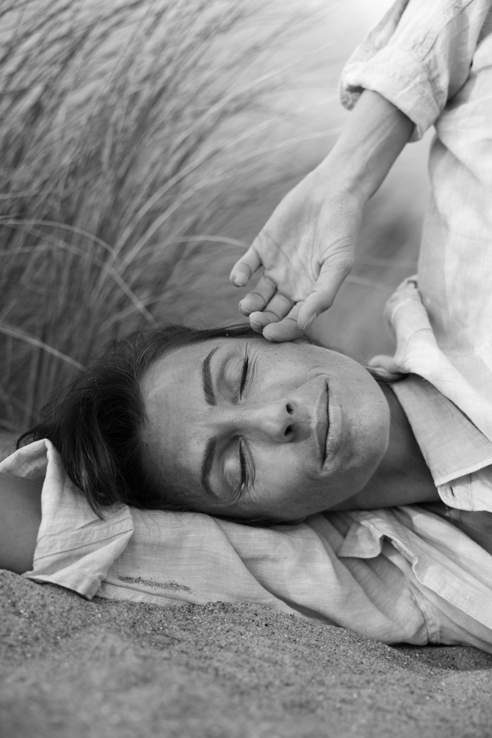 Femme allongée, main posée sur l’épaule, en noir et blanc