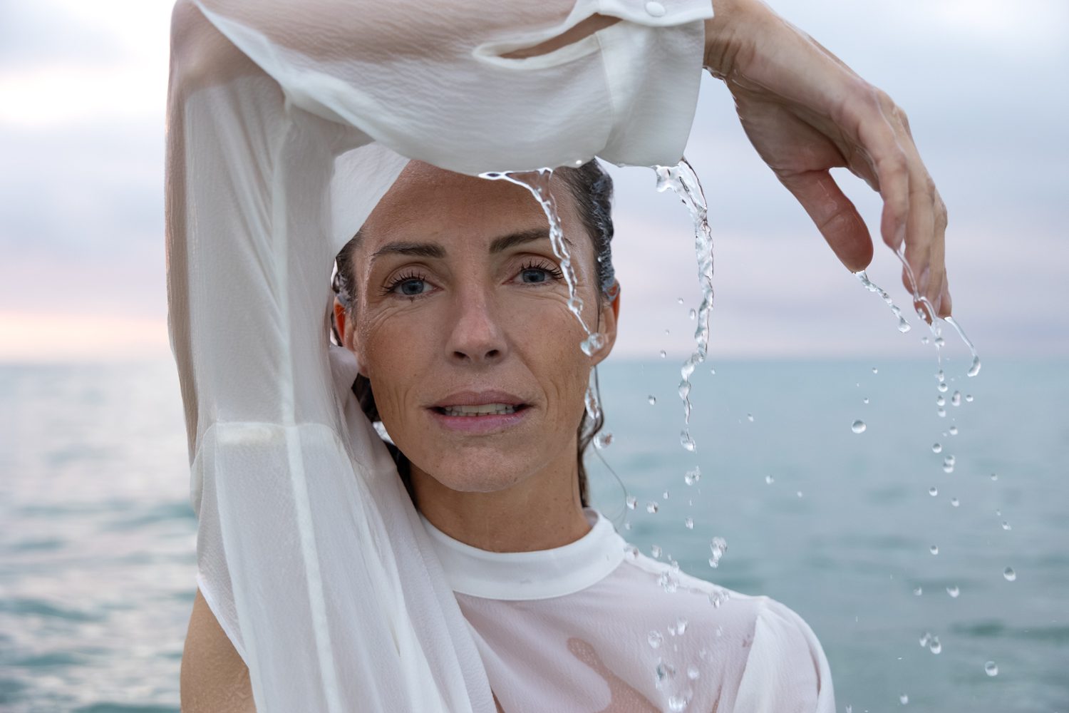 Femme levant les bras dans l’eau, mouvement fluide