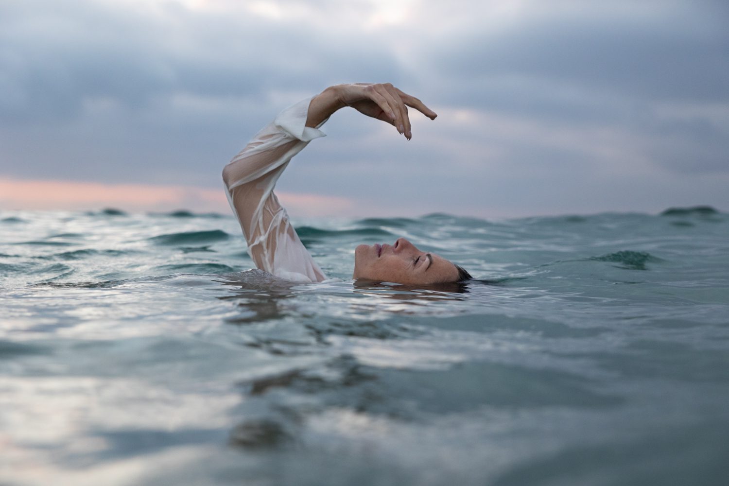 Femme flottant sur l’eau, regard vers le ciel