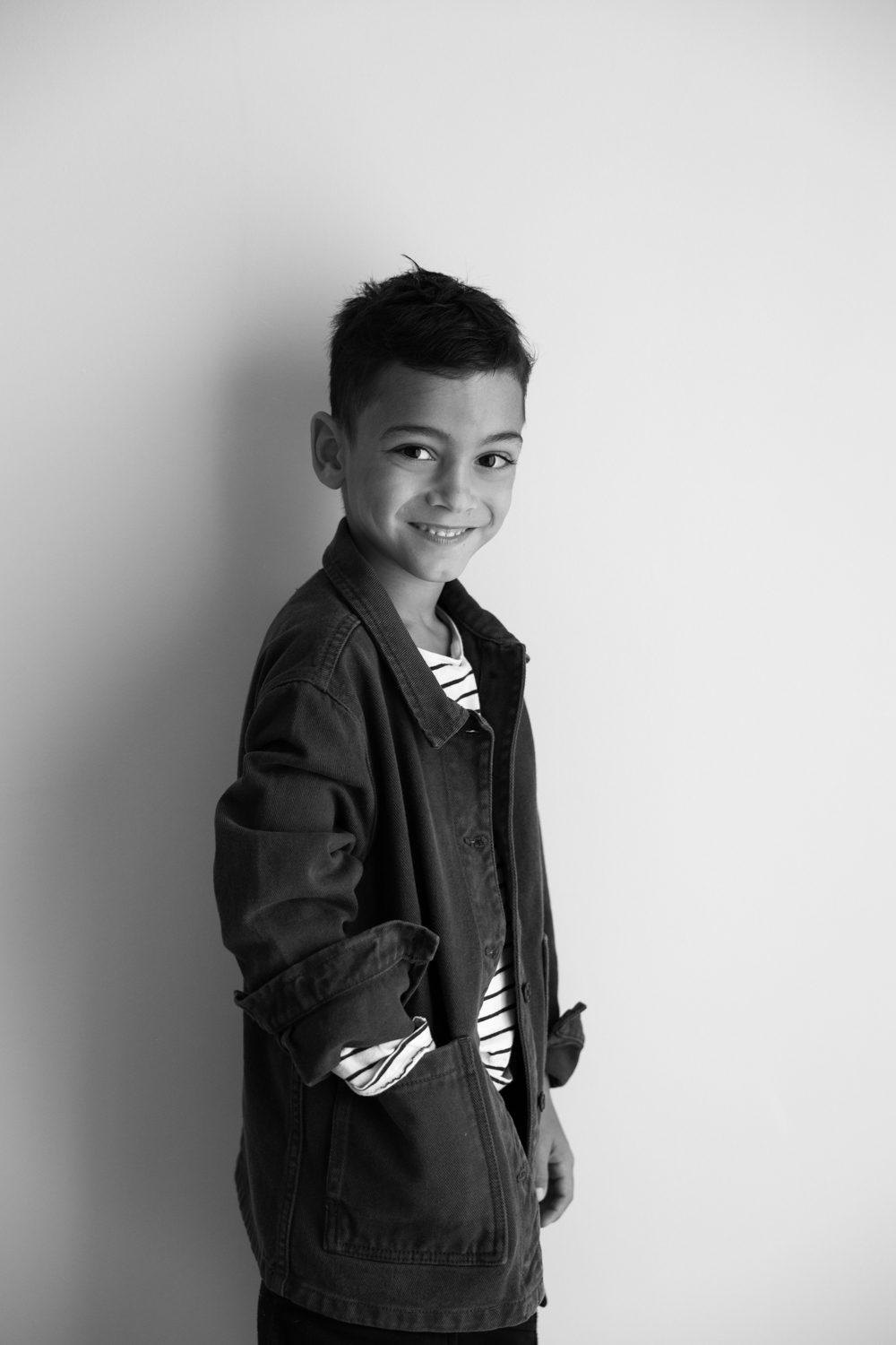 Garçon debout, veste sombre, portrait en noir et blanc