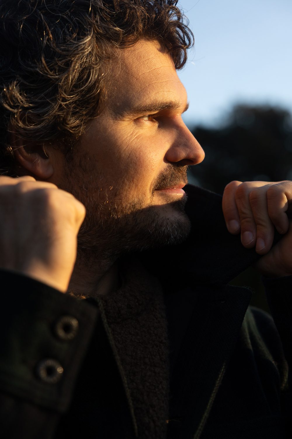 Homme de profil, main près du visage, lumière chaude