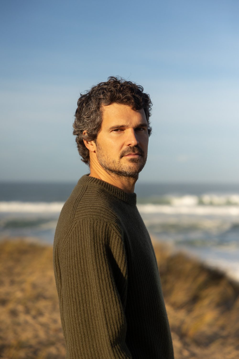 Homme debout sur la plage, lumière douce