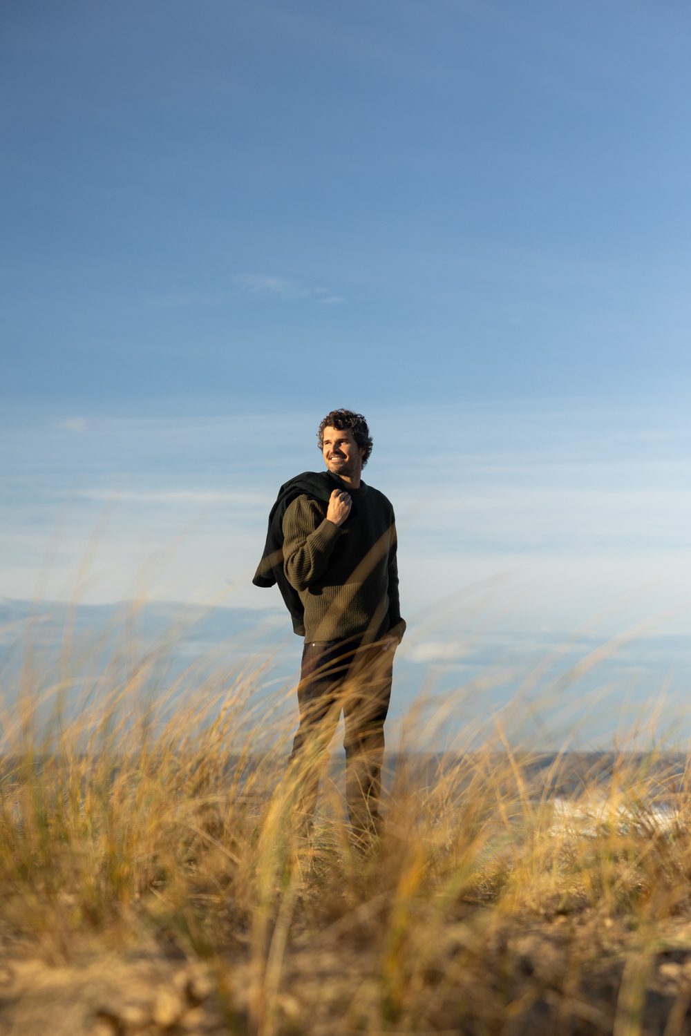 Homme debout près de la mer, regard vers l’horizon