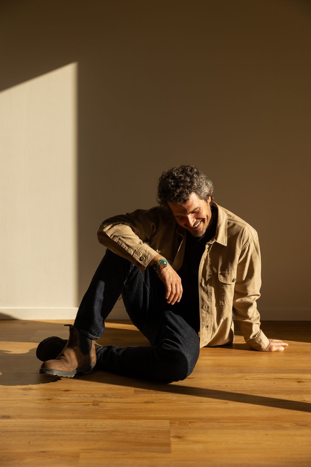 Homme assis au sol, regard vers la caméra