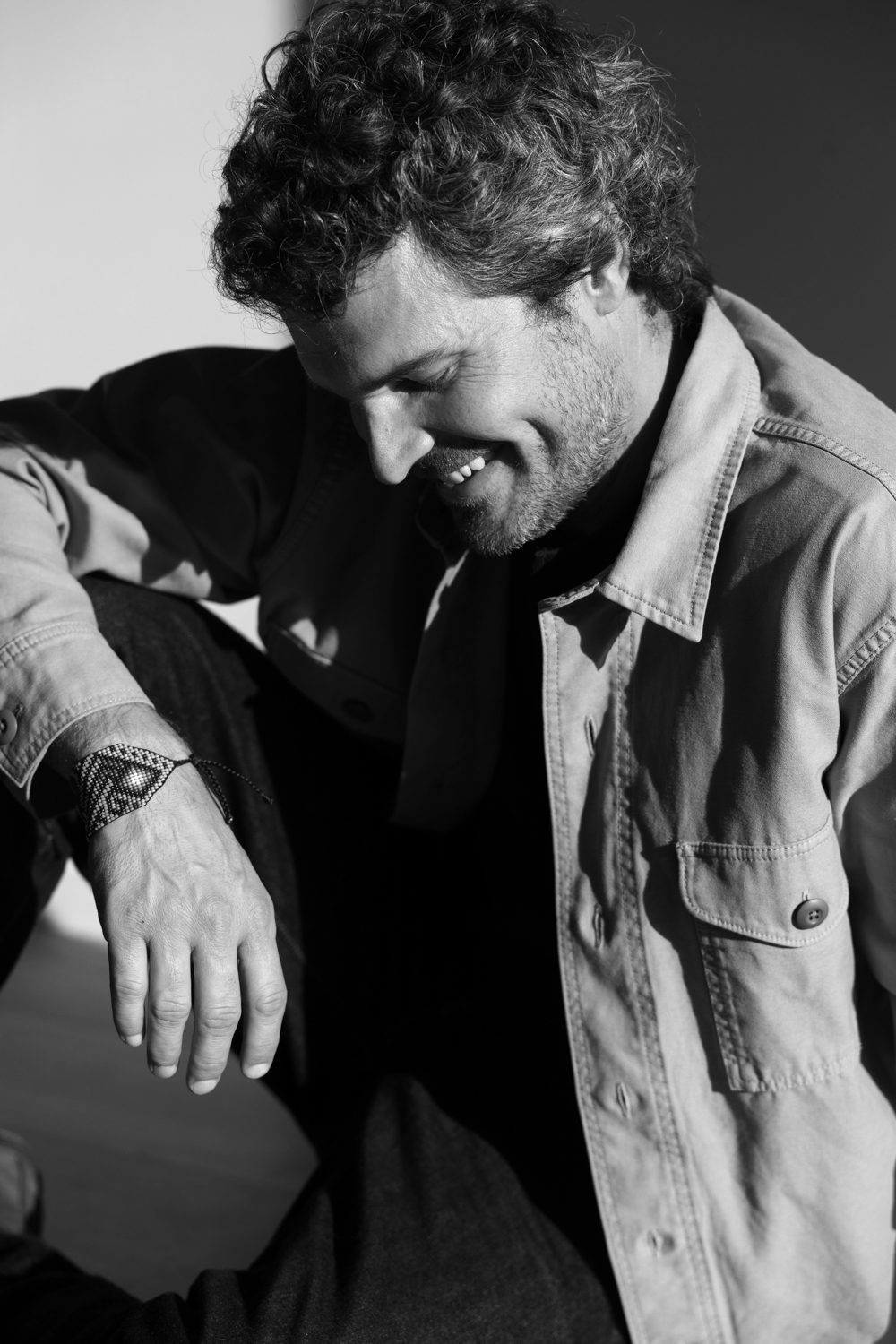 Homme assis, regard vers le sol, en noir et blanc