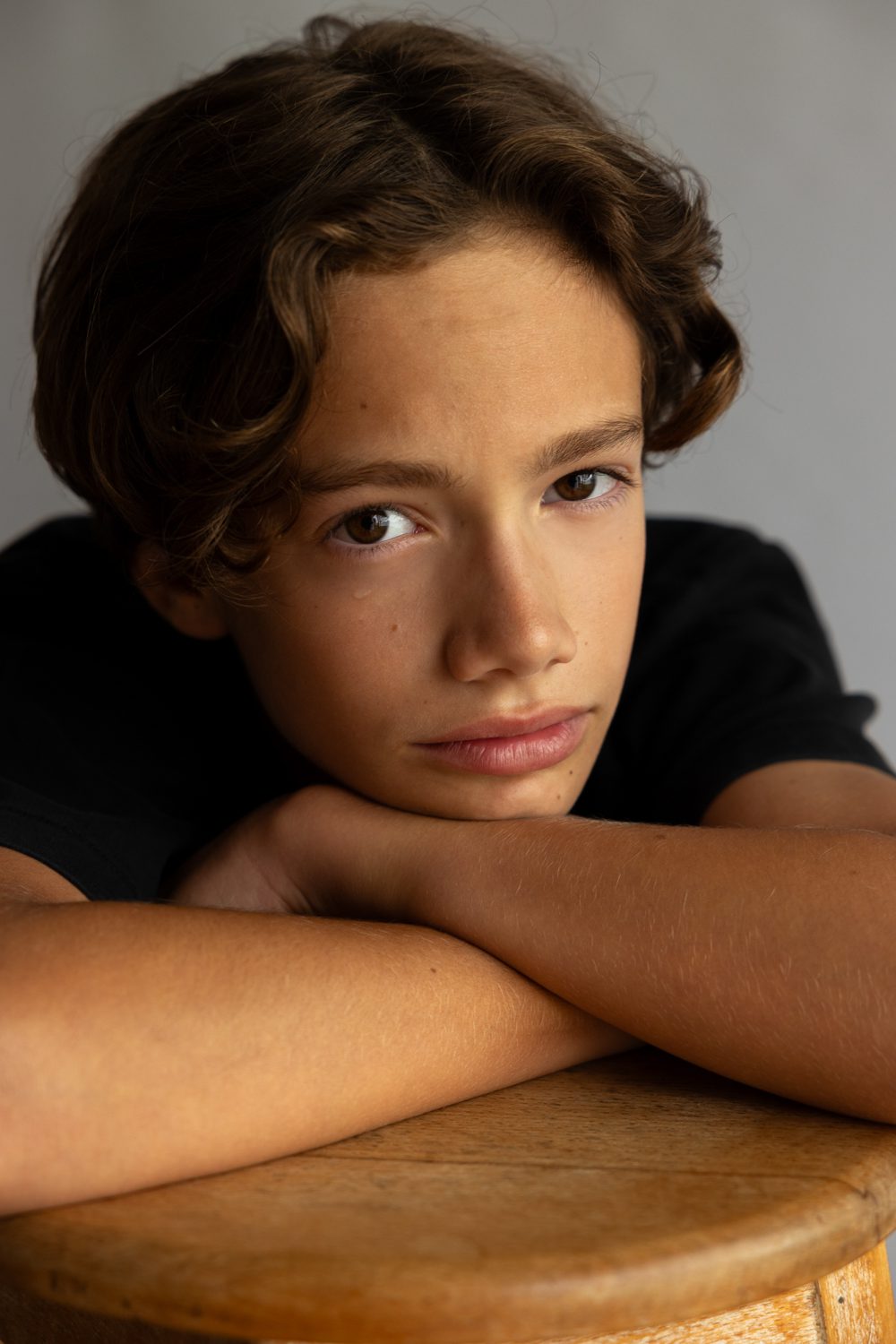 Garçon appuyé sur ses bras, regard calme