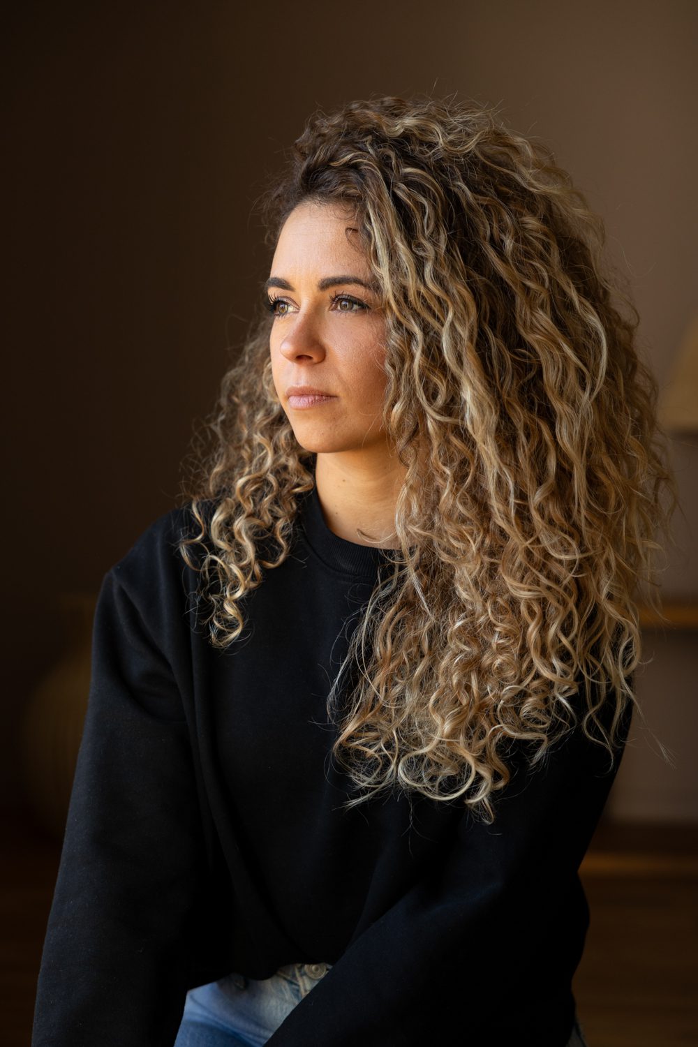 Portrait de femme aux cheveux bouclés, fond sombre